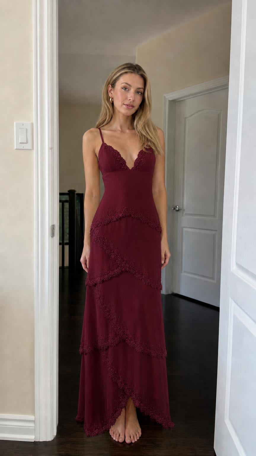 Front view of woman wearing burgundy tiered lace maxi dress