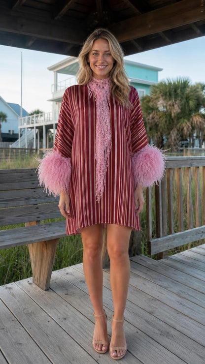 Front view of model wearing burgundy stripe dress with pink feather cuffs