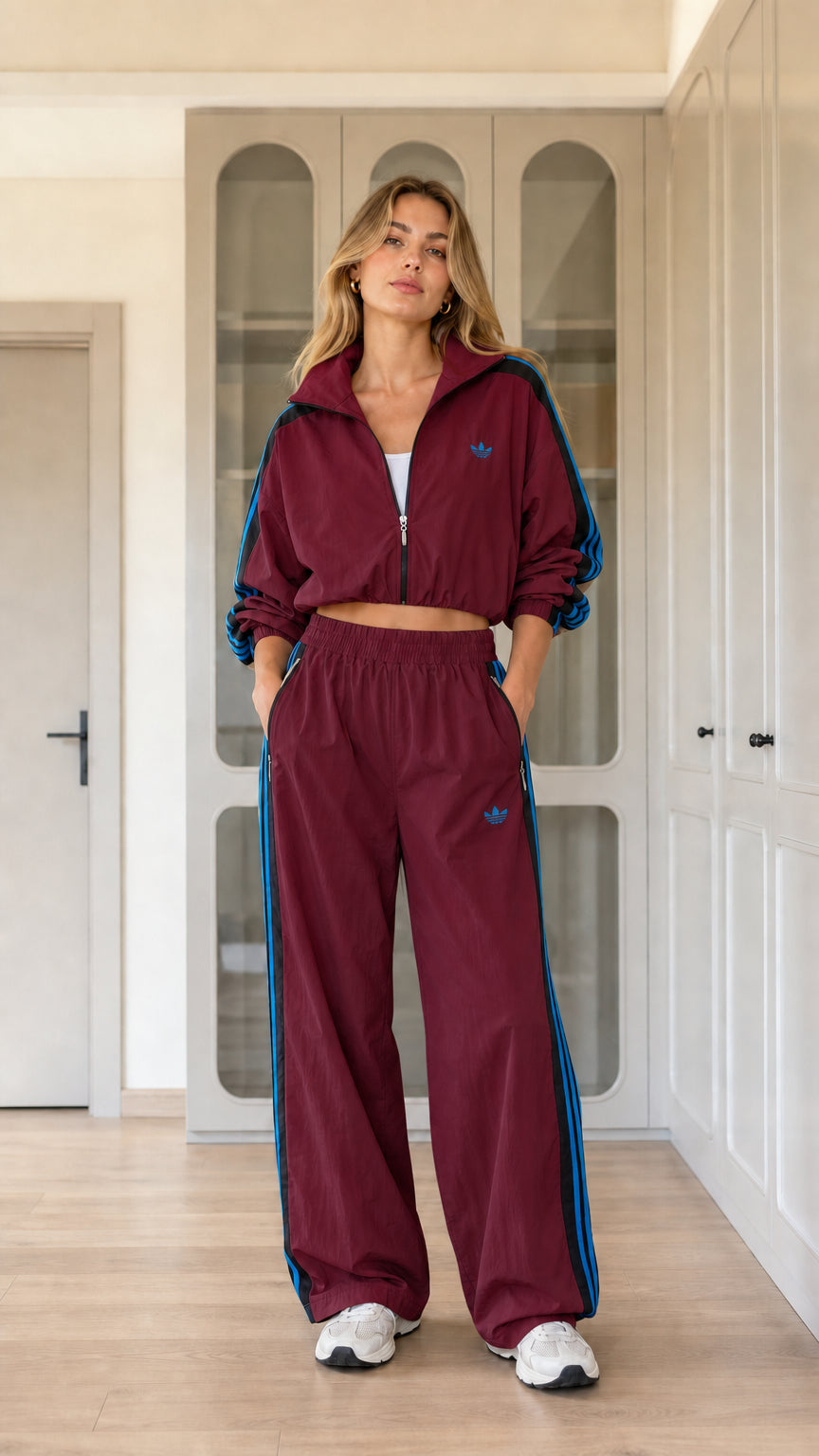 Model wearing burgundy red two-piece windbreaker track jacket and pants set