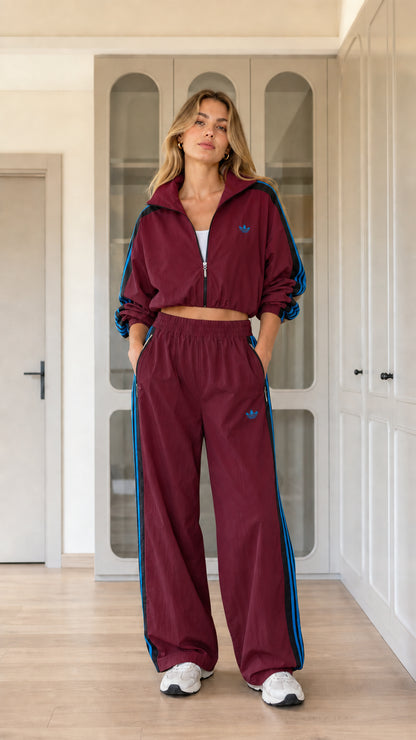 Model wearing burgundy red two-piece windbreaker track jacket and pants set
