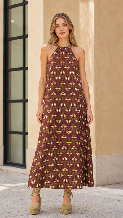 Model wearing brown geo print halter maxi dress