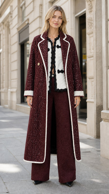 Model wearing rich burgundy sequin tweed longline overcoat with white trim
