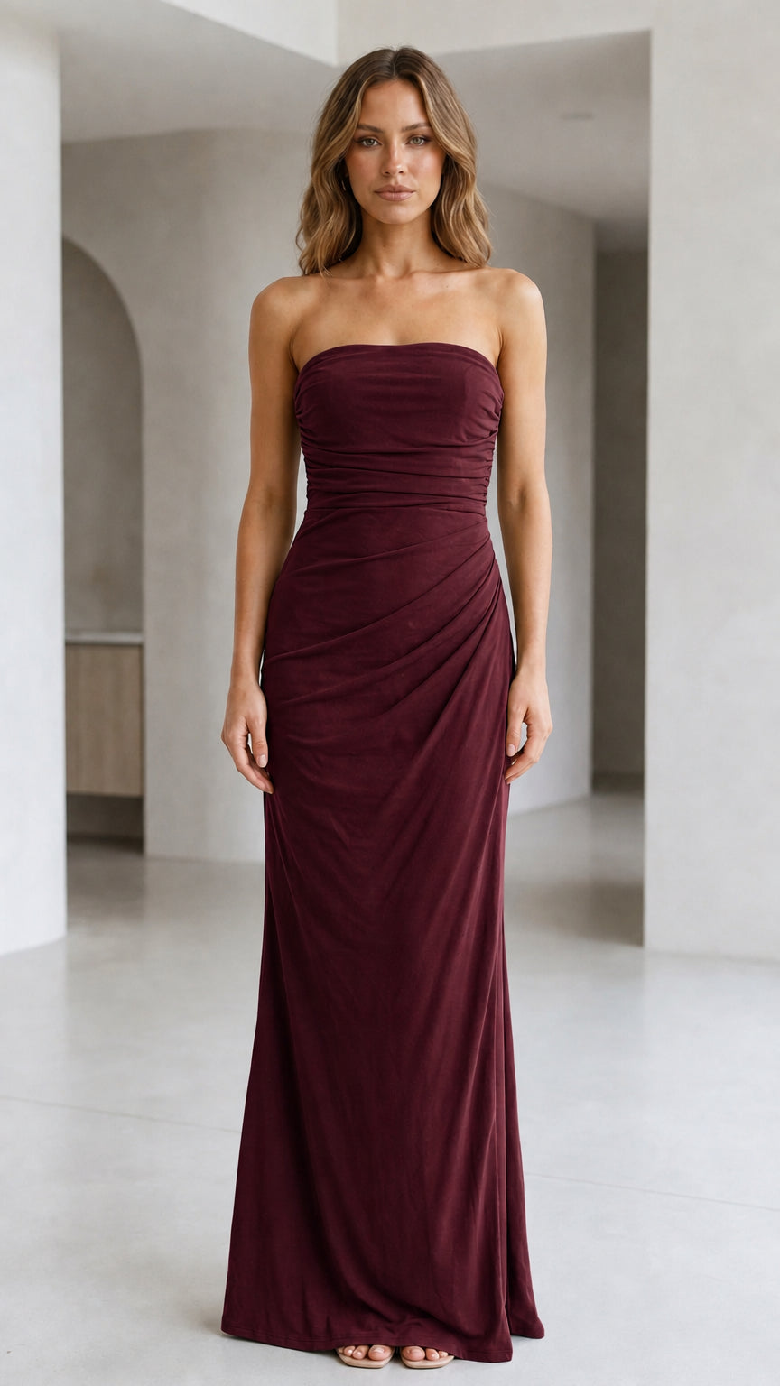 Front view of woman wearing strapless ruched maxi dress in burgundy wine