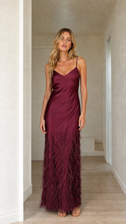 Woman wearing burgundy satin feather trim maxi slip dress