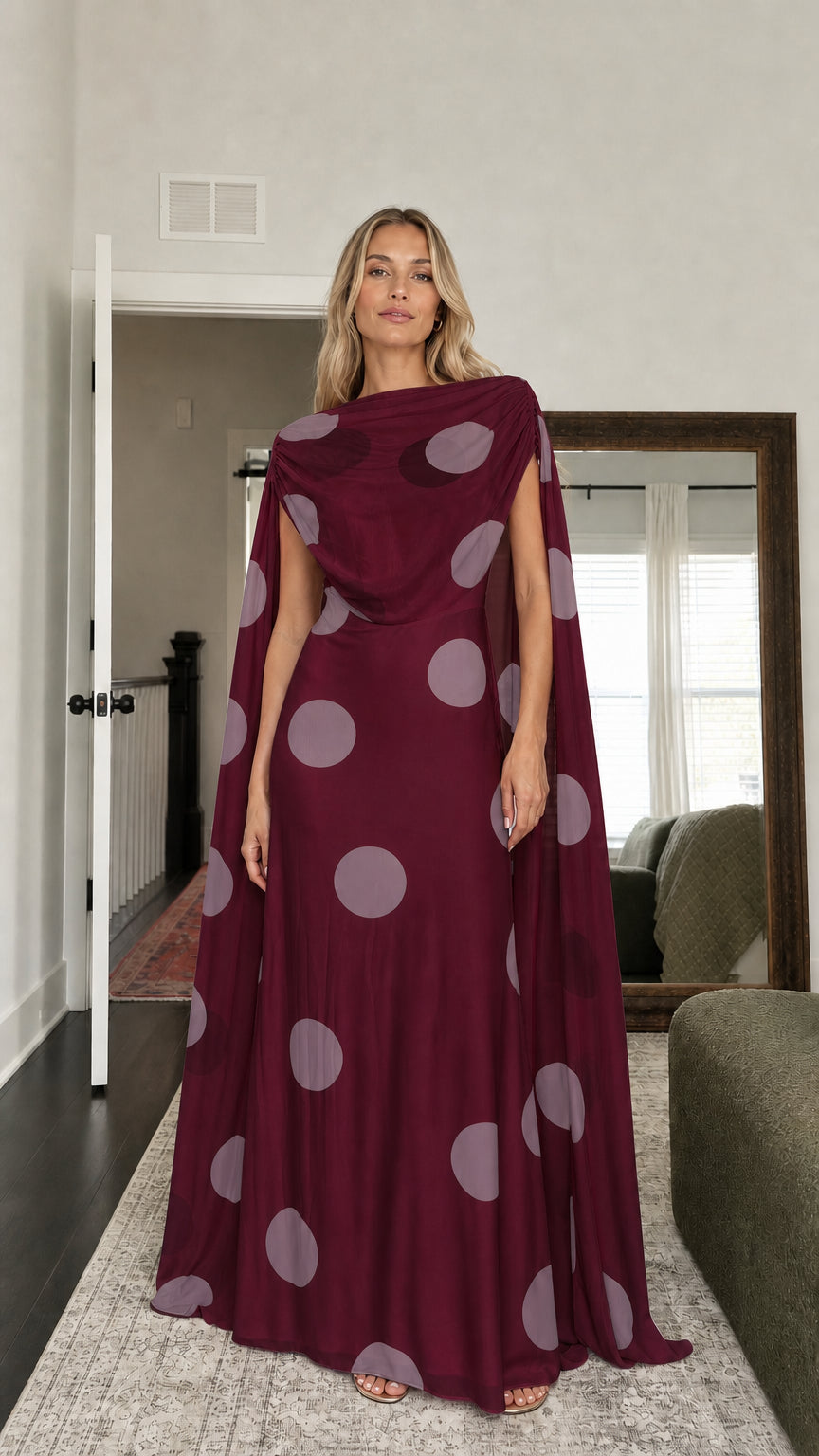 Model wearing burgundy polka dot cape maxi dress