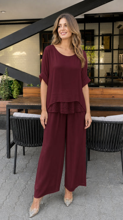 Model wearing burgundy layered tunic and wide-leg pants set