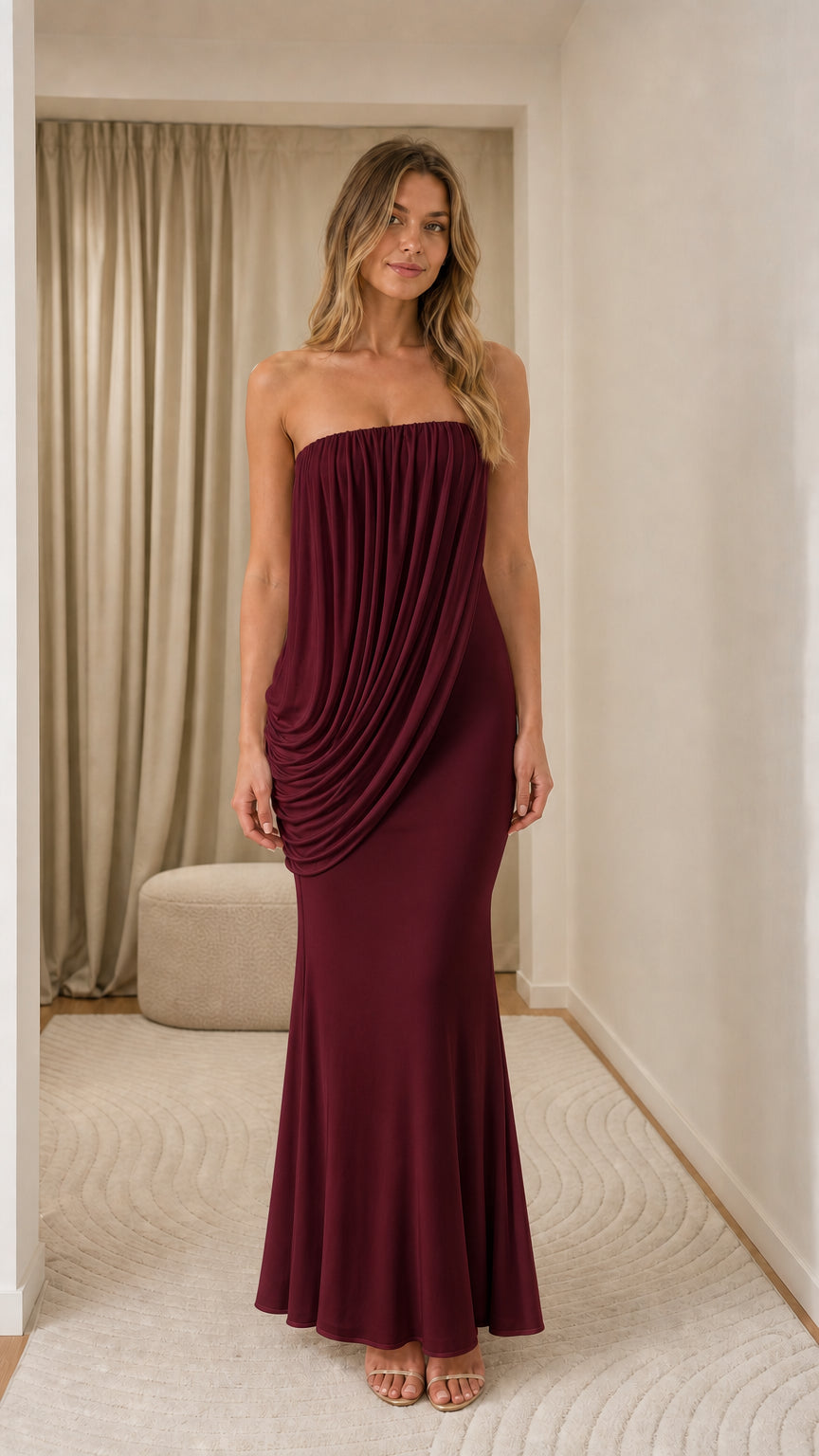 Model wearing burgundy strapless draped maxi dress