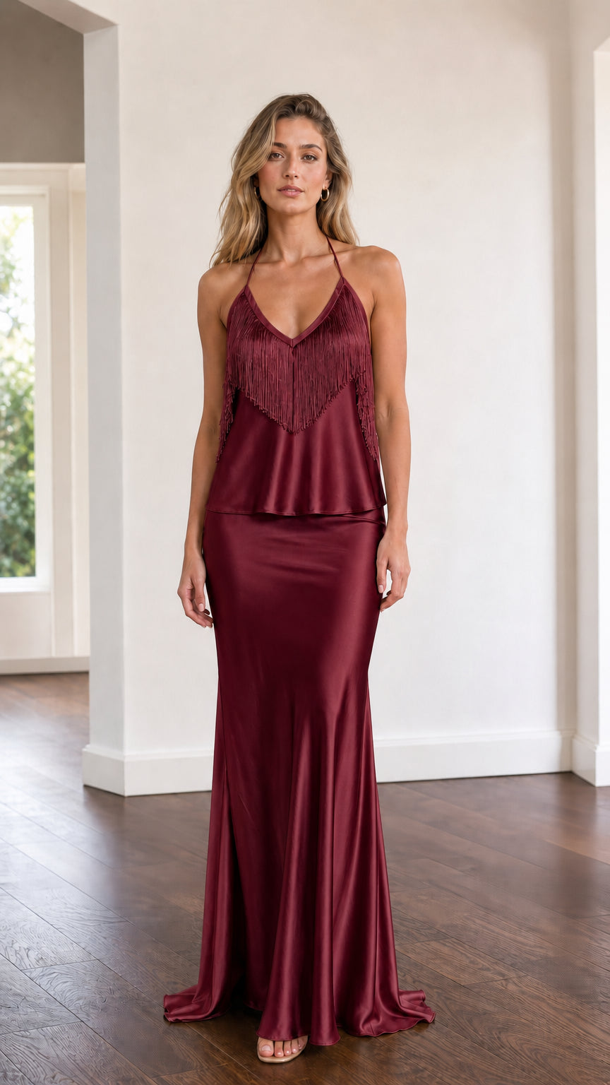 Model wearing burgundy satin halter fringe two-piece set