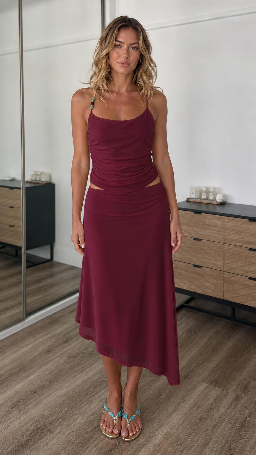Front view of model wearing burgundy two-piece cami top and midi skirt set