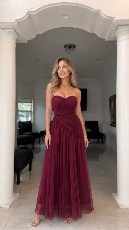 Front view of model wearing burgundy strapless ruched tulle gown