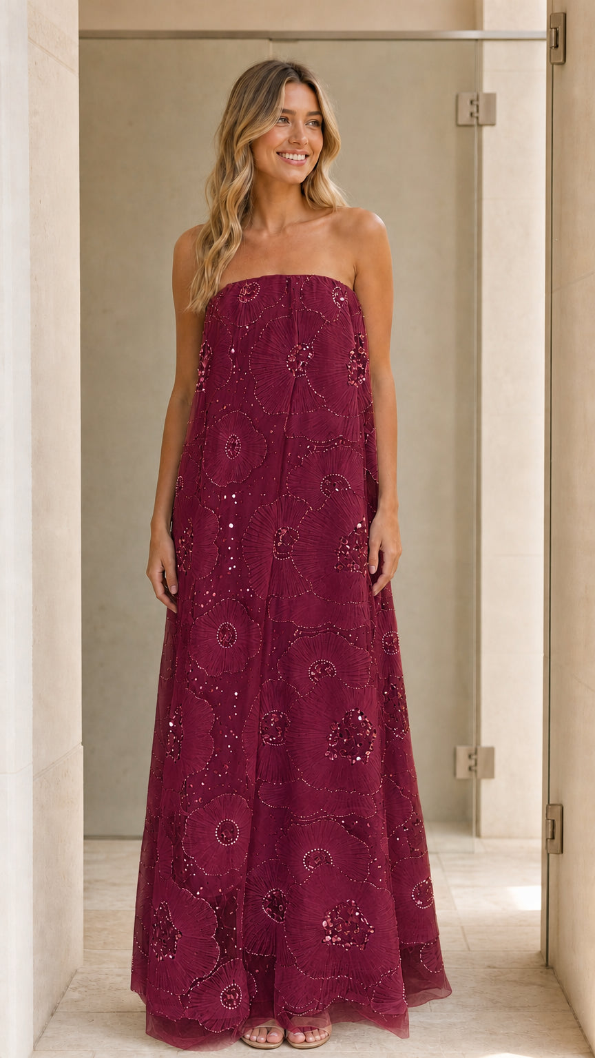 Model wearing burgundy strapless sequin floral maxi dress