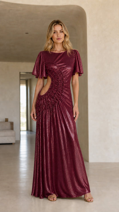 Front view of woman wearing the burgundy color variant of the metallic cutout maxi dress