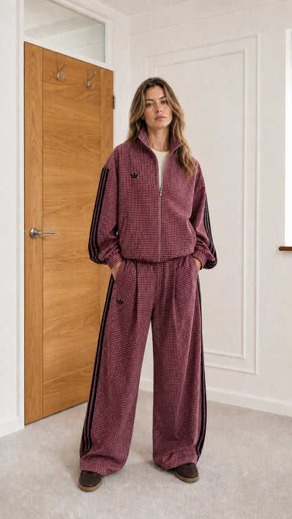Model wearing burgundy houndstooth track jacket and matching wide-leg pants set