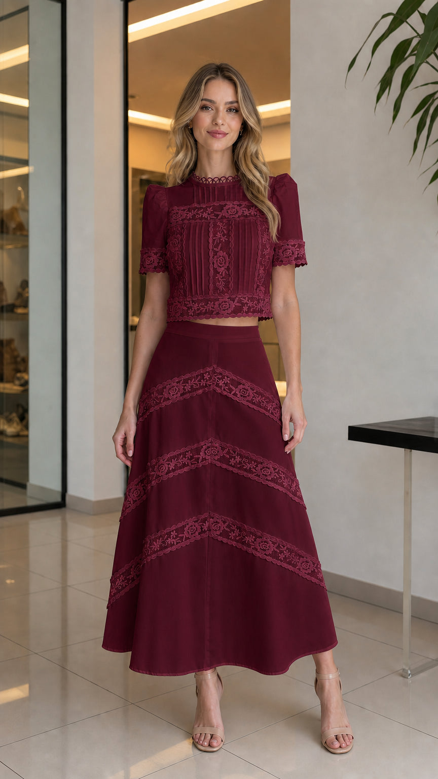 Full-body view of woman wearing burgundy lace crop top and matching skirt set