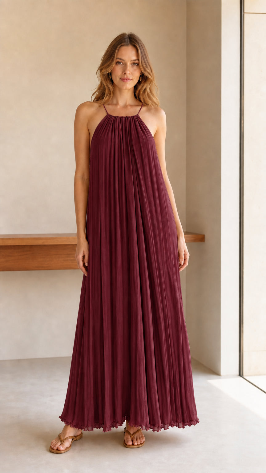 Model wearing burgundy pleated halter maxi dress