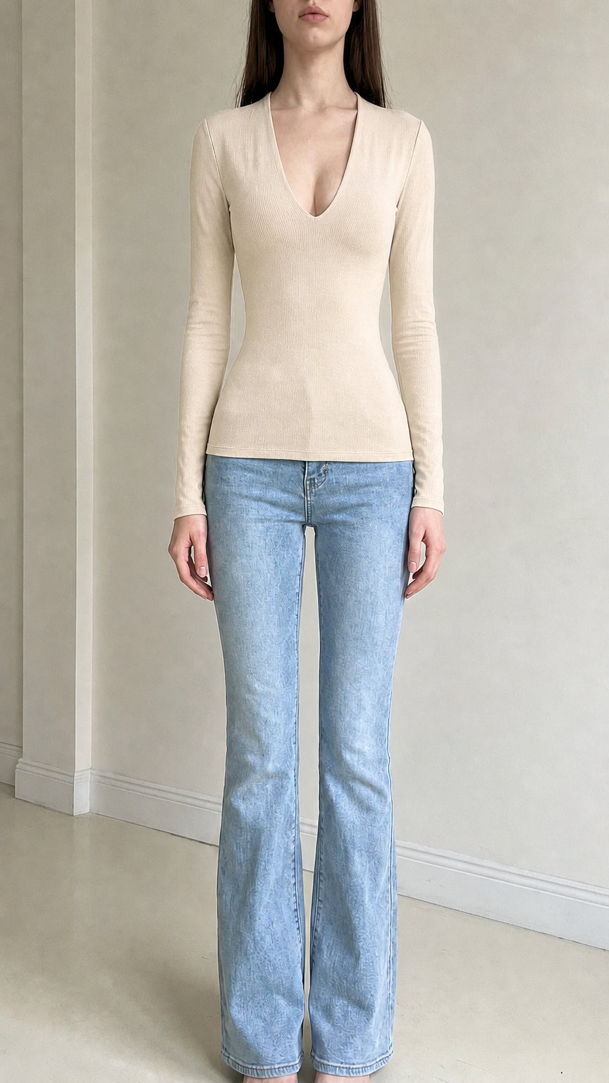 Front view of woman wearing beige deep v-neck long sleeve top