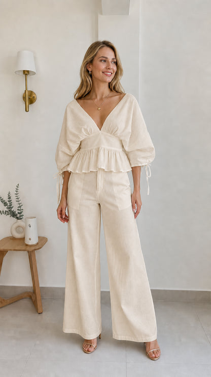 Model wearing beige two-piece peplum and wide-leg pants set