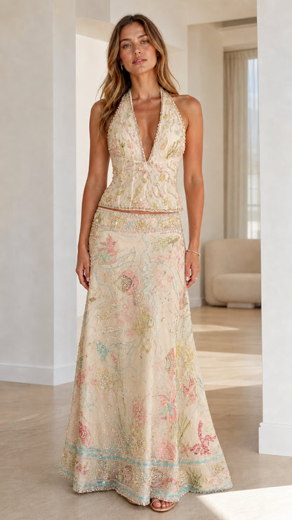 Woman wearing champagne embroidered halter crop top and maxi skirt set