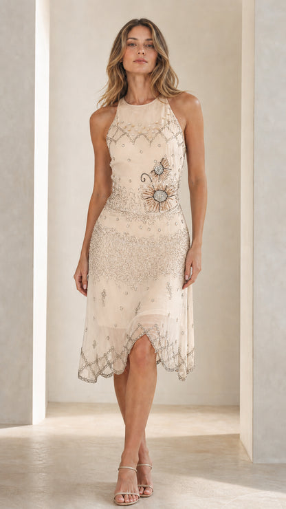 Front view of model in champagne embellished halter midi dress