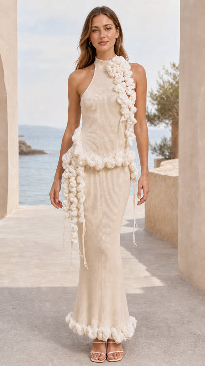 Full-length view of beige cream halter neck ribbed knit maxi dress with cream pom pom trim