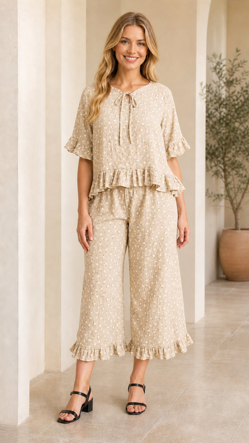 Front view of model wearing beige floral tie-neck ruffle top and cropped pants set