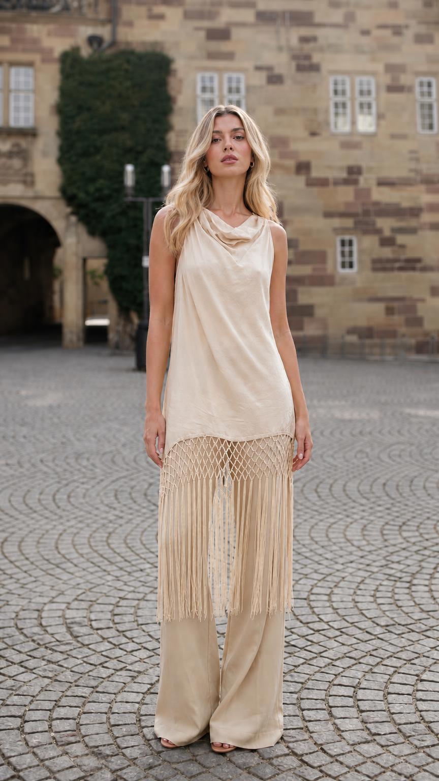 Front view of model wearing beige fringe tunic