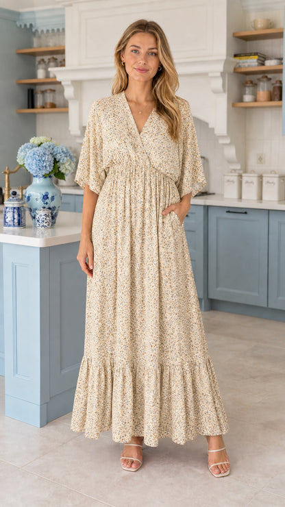 Front view of model wearing cream floral tiered maxi dress with pockets