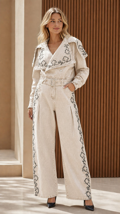 Model wearing cream embroidered denim jumpsuit