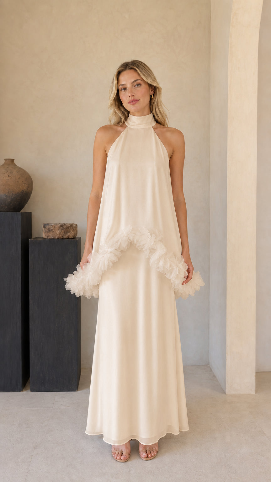Model wearing champagne cream halter evening maxi gown