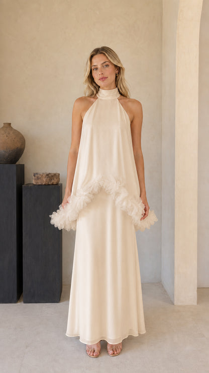Model wearing champagne cream halter evening maxi gown