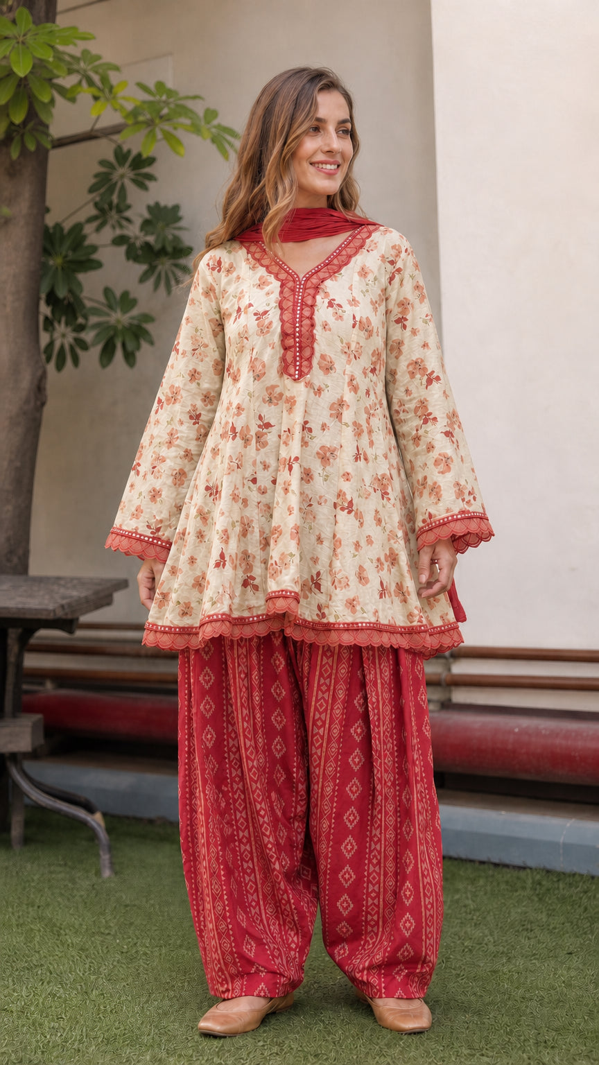 Model wearing beige floral peplum tunic with red dhoti pants