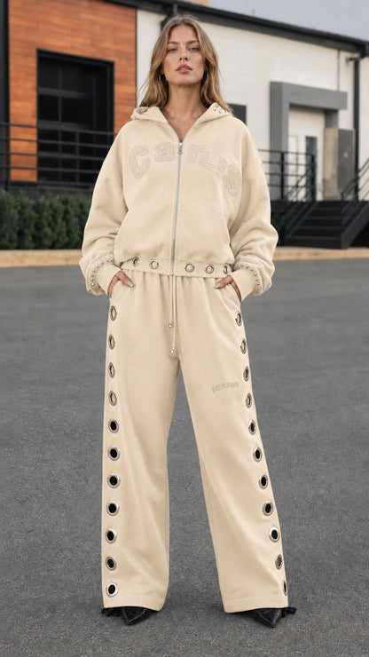 Full front view of model wearing cream beige studded hoodie and wide-leg tracksuit set