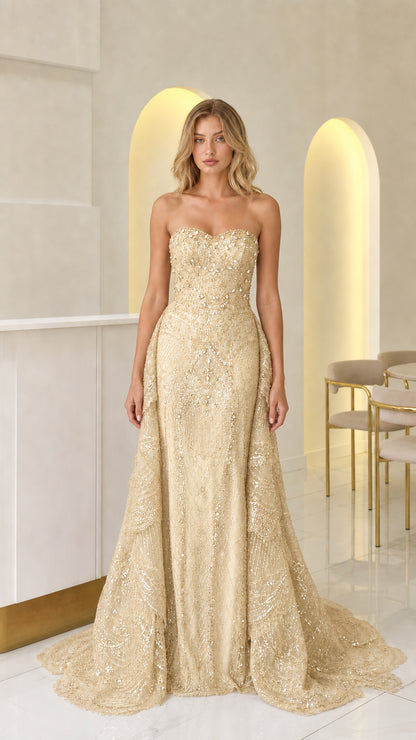 Front view of champagne gold strapless beaded evening gown with train