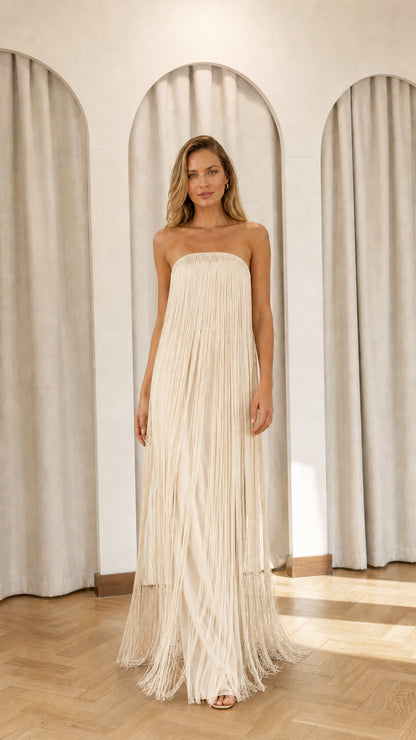 Full view of model wearing champagne strapless fringe maxi dress