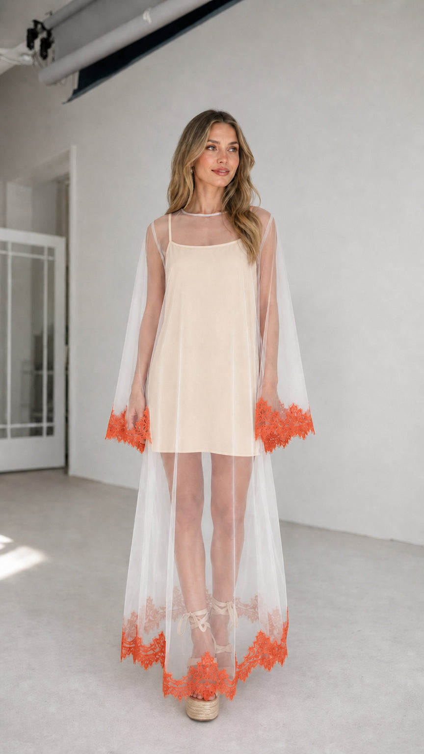 Model wearing champagne inner dress with white embroidered mesh duster