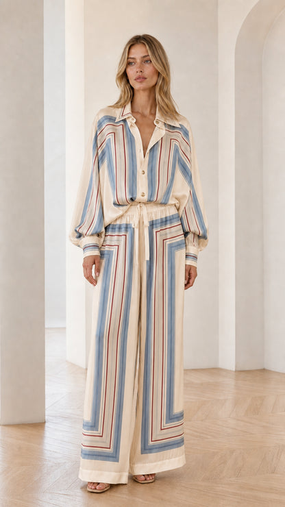 Model wearing cream geometric striped two-piece set