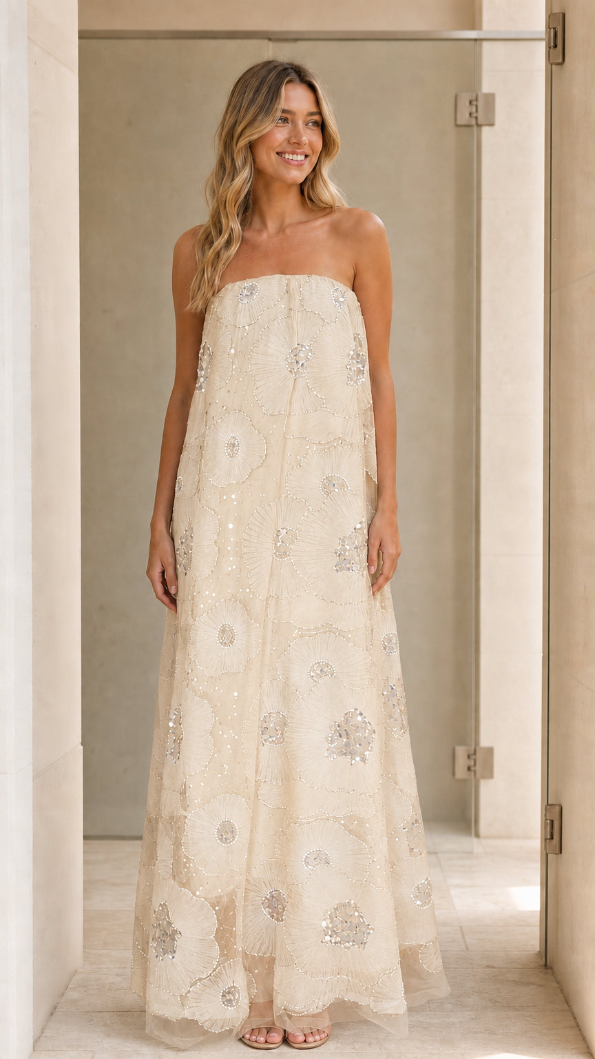 Model wearing champagne strapless sequin floral maxi dress