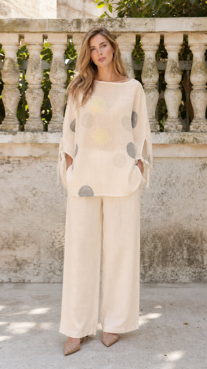 Front view of woman wearing beige polka dot two-piece set
