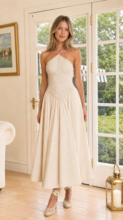 Model wearing cream halter neck smocked basque waist striped midi dress