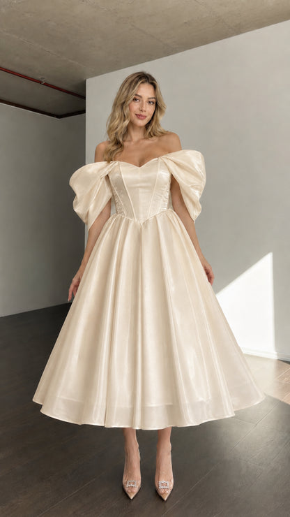 Front view of woman wearing champagne off-shoulder corset midi dress