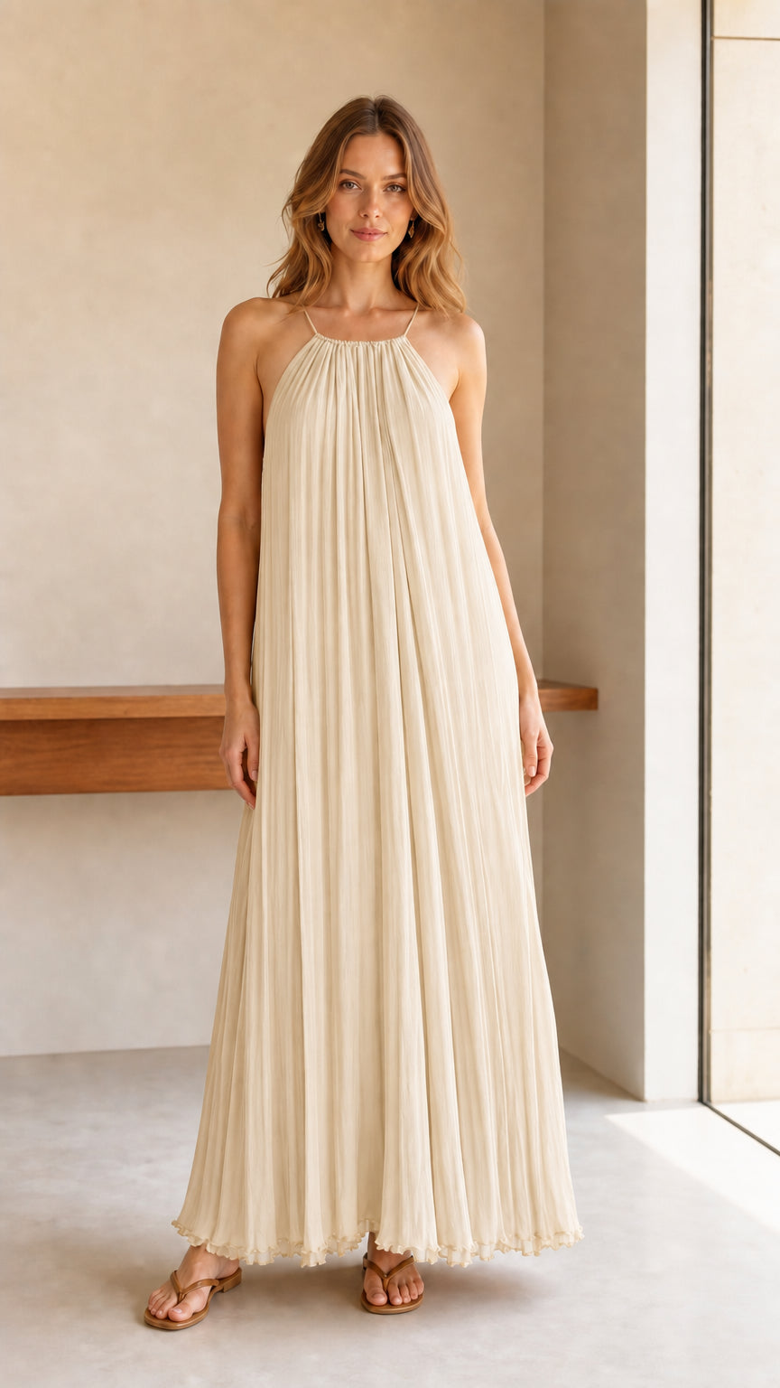 Model wearing cream pleated halter maxi dress