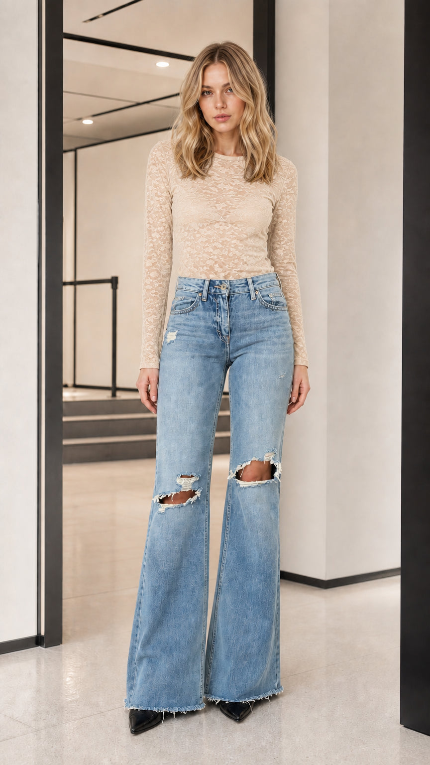 Model wearing beige long-sleeve sheer lace top with flare jeans