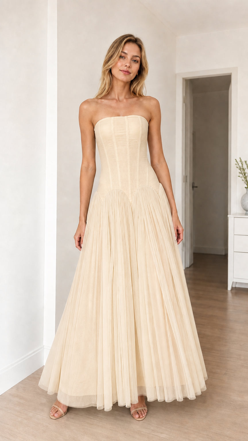 Model wearing champagne strapless corset tulle maxi dress