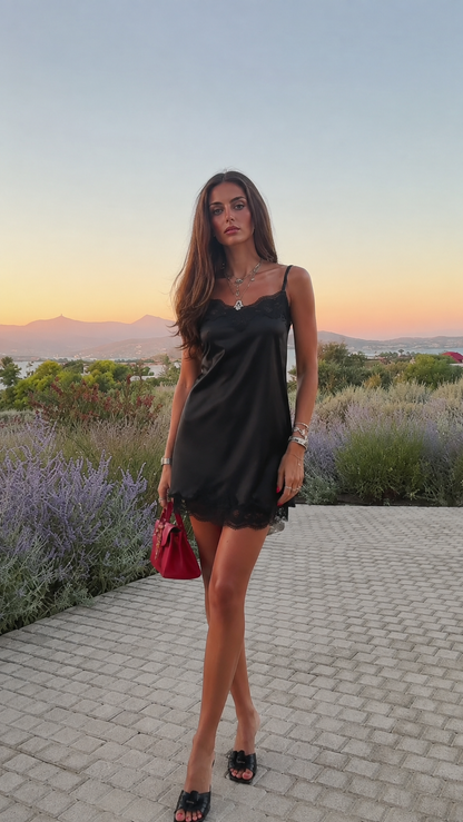 Woman wearing solid black satin slip dress with lace trim
